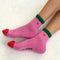 model wearing pink crew socks with green trim and red embroidered heart