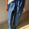 model wearing cotton denim blue pants with workmen patches down the front and inner drawstring