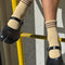 Model wearing tan socks with three brown stripes at the top and black flats
