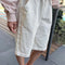 model wearing white cotton relaxed fit bermuda shorts