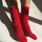 model wearing poppy red pointelle socks