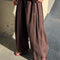side view of model wearing dark brown oversized parachute pants