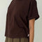 side view of model wearing dark brown relaxed fit tee