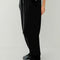 side view of model wearing black waffle knit pants with elastic waist and side pockets