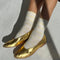 model wearing white socks with thin pale yellow stripes with gold flats