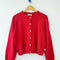 chili red cotton cardigan on a hanger