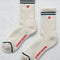 white high screw socks with red and blue stripes on the top and red embroidered heart