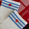up close of model wearing cream high crew socks with triple light blue stripes and embroidered red heart
