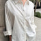 model wearing white relaxed fit button front shirt with side vents and collar