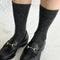 model wearing charcoal pointelle tall crew socks with black loafers