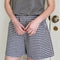 model wearing navy and white gingham cotton shorts with side pockets