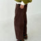side view of model wearing chocolate brown corduroy arc pants with side panels and pockets