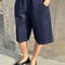 model wearing dark blue bermuda shorts with side pockets