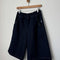 dark blue bermuda shorts with side pockets on a hanger