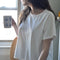 model wearing relaxed, slightly cropped clean white tee with distressing on the neckline