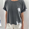 model wearing relaxed, slightly cropped washed black tee with distressing on the neckline