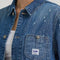 up close of model wearing blue relaxed fit chore jacket with faint pinstripes, white bleach splatters and patch pockets