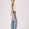 side view of model wearing medium denim wash with tan wash on the legs