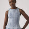model wearing acid washed peplum tank top with several inlets