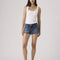 model wearing dark denim low rise shorts with frayed hem