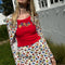 model wearing white cotton mini skirt with red lettuce trim, red bow front, and retro primary color floral print