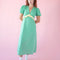 model wearing green puff sleeve v-neck midi dress with pale yellow ruffle under the bust