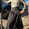 model wearing black twill midi skirt with wavey hem detail