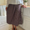 model wearing brown striped midi skirt with asymmetrical detail on the waist