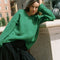 model wearing green textured v-neck sweater and twill skirt