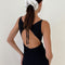 back view of model wearing black crinkle maxi dress with asymmetrical hem and open back