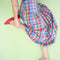 model wearing colorful plaid midi skirt with drop waist