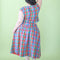 back view of model wearing colorful plaid midi skirt with drop waist