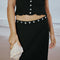 up close of model wearing black crinkle midi skirt with shaped shell buttons on the top and matching tank