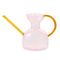 light pink abstract shaped watering can with amber colored spout and handle