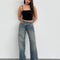 model wearing blueish-green low rise wide leg denim and black tank