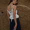 back view of white gathered cropped tank with ruffle bust and tie waist