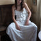 model wearing white asymmetric maxi skirt with lace and embroidery detail while sitting