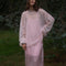 model wearing sheer pink oversized sweater over a pink midi dress