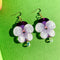 purple pansy dangle earrings with a pretty bead on the bottom on a lime ground