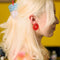 model wearing red large button earrings