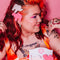 model wearing pink and white animal cookie hair clips with multicolor rhinestone details