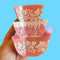 model holding pink and white stacked 'pyrex' bowl inspired hair claw