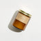 arroyo oak standard candle in a amber colored jar and gold twist lid