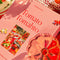 up close of boxed 'tomato tomahto' 1000 piece puzzle with various tomato items on a red tiled table