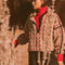model wearing tan fleece half zip sweatshirt with red floral print and black piping on the arms and zipper
