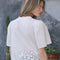 back view of model wearing white scalloped hem blouse with slight puff sleeves and faux button front