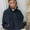 model wearing buttoned oversized high neck denim cropped jacket with tie drawstring hem