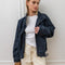 model wearing oversized high neck denim cropped jacket with tie drawstring hem