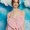 up close of model wearing light pink bubble mini dress with jacquard texture, spaghetti straps and oversized bow