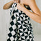 model with black and white geometric bath towel wrapped around themselves